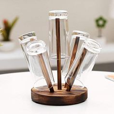 several glass cups and wooden sticks in a holder on top of a white coffee table