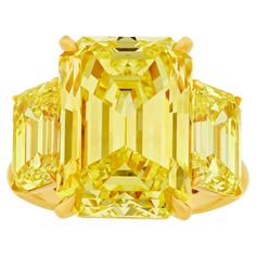 This exceptionally rare fancy intense yellow diamond ring showcases three emerald cut yellow diamonds, with the center stone totaling 10.37 carats and the two accent stones totaling 3.75 carats. Discovering a single fancy intense yellow diamond of this caliber is rare; finding three perfectly matched stones with such vivid color is nearly unprecedented. The center stone is certified by the Gemological Institute of America (GIA) as internally flawless, the highest clarity grading distinction a diamond can receive. Each diamond is certified by the GIA as having the coveted all-natural fancy intense yellow color grade. The ring is set in 18K yellow gold, perfectly accentuating these captivating, sunny gems. Fancy Yellow Diamond Ring, Canary Yellow Diamonds, Canary Diamond, Yellow Diamond Ring, Expensive Diamond, Yellow Diamonds, Yellow Diamond Rings, Yellow Jewelry, Fancy Yellow Diamond