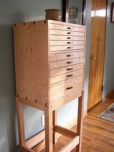 a tall wooden cabinet sitting on top of a hard wood floor