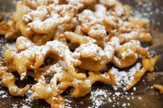 powdered sugar coated pastries on a wooden cutting board