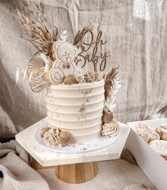 a white cake sitting on top of a table next to cookies and cupcakes