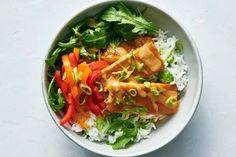 a white bowl filled with rice, meat and veggies on top of it