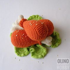 an orange stuffed animal laying on top of green leaves