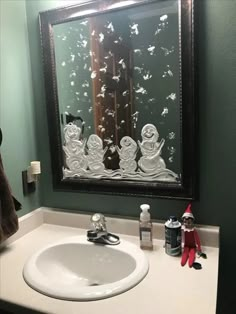 a bathroom sink under a large mirror next to a towel rack and toothbrush holder