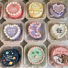 twelve decorated heart shaped donuts in plastic trays with writing on the top and bottom