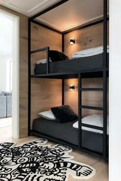 bunk beds in a room with wood paneling and rugs on the floor next to each other