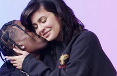 a man and woman embracing each other in front of a purple background