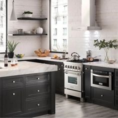 a kitchen with black cabinets and white walls