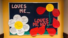 a bulletin board with flowers and notes attached to it that read loves me, loves me not