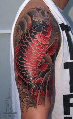 a man with a tattoo on his arm has a red fish in it's body