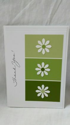 a greeting card with three flowers on green and white cardstocked to each other