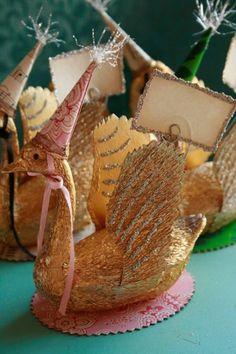 three little boats made out of straws on a blue tablecloth with pink ribbon