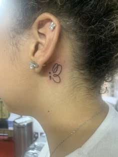 a woman with a small tattoo behind her ear