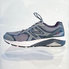 a pair of new balance shoes is shown on a white surface with reflections in the background