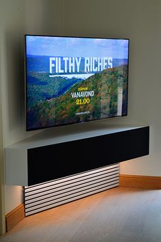 a flat screen tv mounted on the side of a wall in a room with hardwood floors