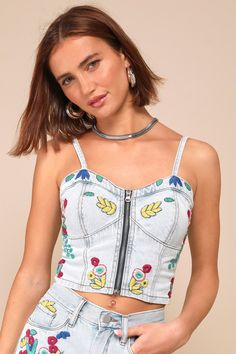 From BBQs to backyard parties, there's nothing cuter than the Blank NYC Picnic Date Light Wash Denim Embroidered Bustier Top! Sturdy cotton denim shapes slender, adjustable straps that support a bustier-style bodice with seamed cups and an exposed front zipper. Flattering seaming and floral embroidery decorate this top, for a cute finish to any summer look. Smocked panel at the back for fit. Fit: This garment fits true to size. Length: Size medium measures 11" from adjustable straps to hem. Bust Summer Denim Top With Floral Embroidery, Floral Embroidered Denim Top For Summer, Embroidered Denim Blue Top For Summer, Fitted Denim Tops With Adjustable Straps, Summer Embroidered Denim Top, Spring Festival Denim Top, Fitted Embroidered Cotton Denim Top, Summer Festival Denim Top, Denim Tops With Adjustable Straps For Summer