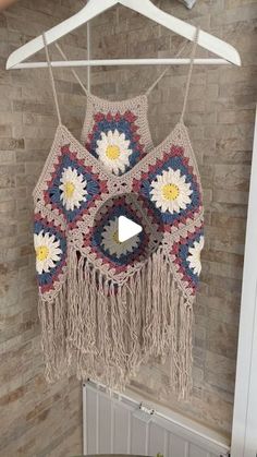 a crocheted doily hanging from a hanger in a room with brick walls