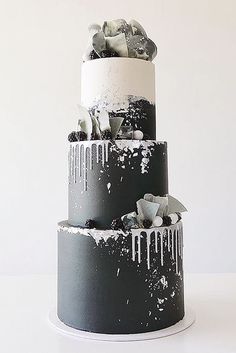 three tiered black and white cake with icing