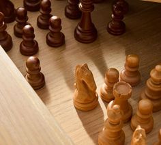 a wooden chess board with pieces on it