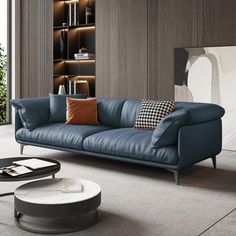 a living room with a blue leather couch and coffee table in front of bookshelves