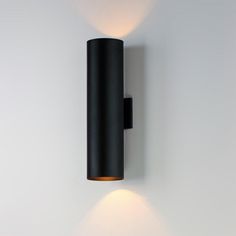 a black wall light mounted on the side of a white wall