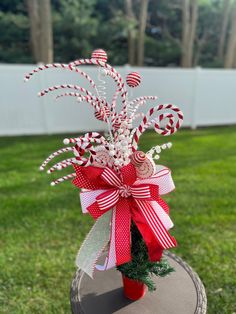 a red and white candy cane arrangement in a vase