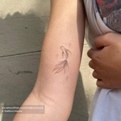 a woman's arm with a tattoo on it that has a bird flying in the air