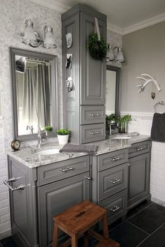 a bathroom with gray cabinets and marble counter tops