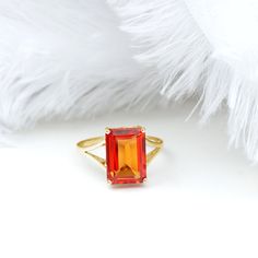 an orange ring sitting on top of a white furnishing next to a feather