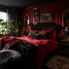 a bedroom decorated in red and black with pictures on the wall above the bed, along with plants