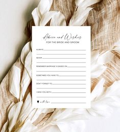 a wedding advice card sitting on top of some white feathers with the words, once and always for the bride and groom