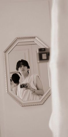 a woman is looking at her reflection in the mirror