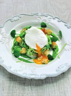 a white plate topped with broccoli and an egg on top of it's side