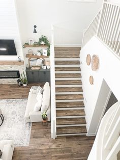 an overhead view of a living room with stairs leading up to the second floor and kitchen