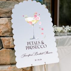 a sign that says petals & prosceco on it next to a table