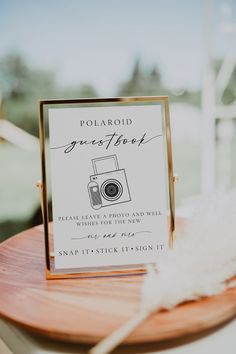 a sign that is on top of a wooden table next to a white feather ornament