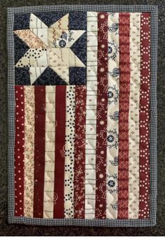 an american flag quilt hanging on the wall