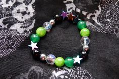 Aromantic pride flag star beaded gemstone bracelet. The beads are the aromantic flag colors (green, light green, white, grey, black) and holographic stars.  ♥ Bracelet Size: - To find the size that fits you best, you can measure the circumference around your wrist; for a comfort/loose fit, add 2cm to that measurement ♥ Handcrafted With: ✔ High-quality gemstone beads ✔ Durable stretchy cord Thank you for visiting! If you have any questions, feel free to contact me!  Instagram: @FrogsMakingToast Handmade Green Star-shaped Jewelry, Green Star-shaped Handmade Jewelry, Casual Green Gemstone Bead Jewelry, Casual Green Gemstone Beads Jewelry, Aromantic Bracelet, Lgbtq Gifts, Lgbtq Jewelry, Aromantic Flag, Stretchy Beaded Bracelet