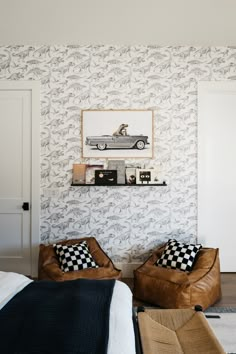 a bedroom with two brown chairs and a black and white checkered blanket on the bed