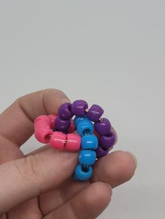 a person is holding some colorful beads in their hand