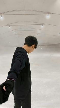 a man standing on top of an ice rink holding his hand out to someone else