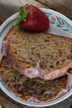 two slices of strawberry banana bread on a plate with a strawberry in the middle and one slice cut off