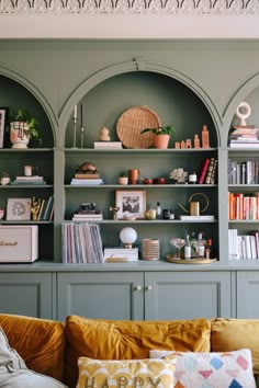 a living room filled with furniture and bookshelves covered in lots of different types of decor