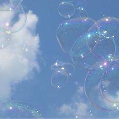 soap bubbles floating in the air on a sunny day with blue sky and white clouds