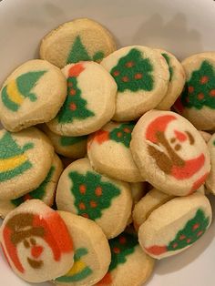 a bowl filled with christmas cookies on top of a table