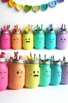 there are many painted mason jars with pencils in them