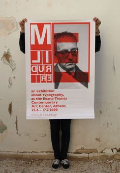 a person holding up a poster with an image of a man