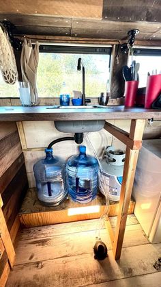 the inside of a camper with water bottles and other items on the counter top