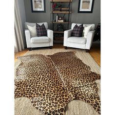 a living room with two white chairs and a leopard print area rug on the floor