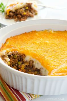 a casserole dish with meat and vegetables in it on a table next to other dishes